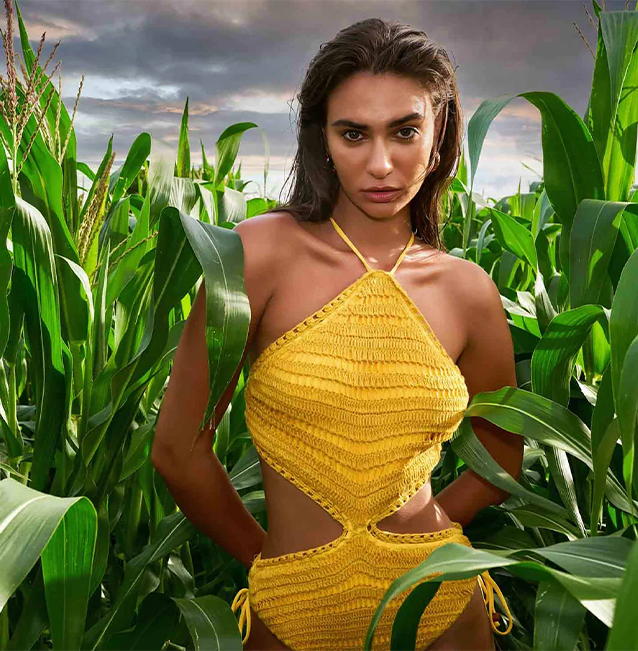 model posing in a yellow hand-crocheted one-piece