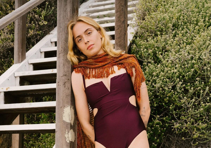 Woman in an aubergine one-piece, a Hamptons outfit idea