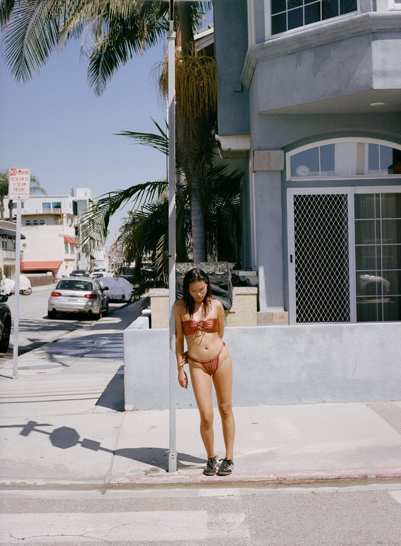 Woman on the curb in a copper bikini, an outfit idea for Miami