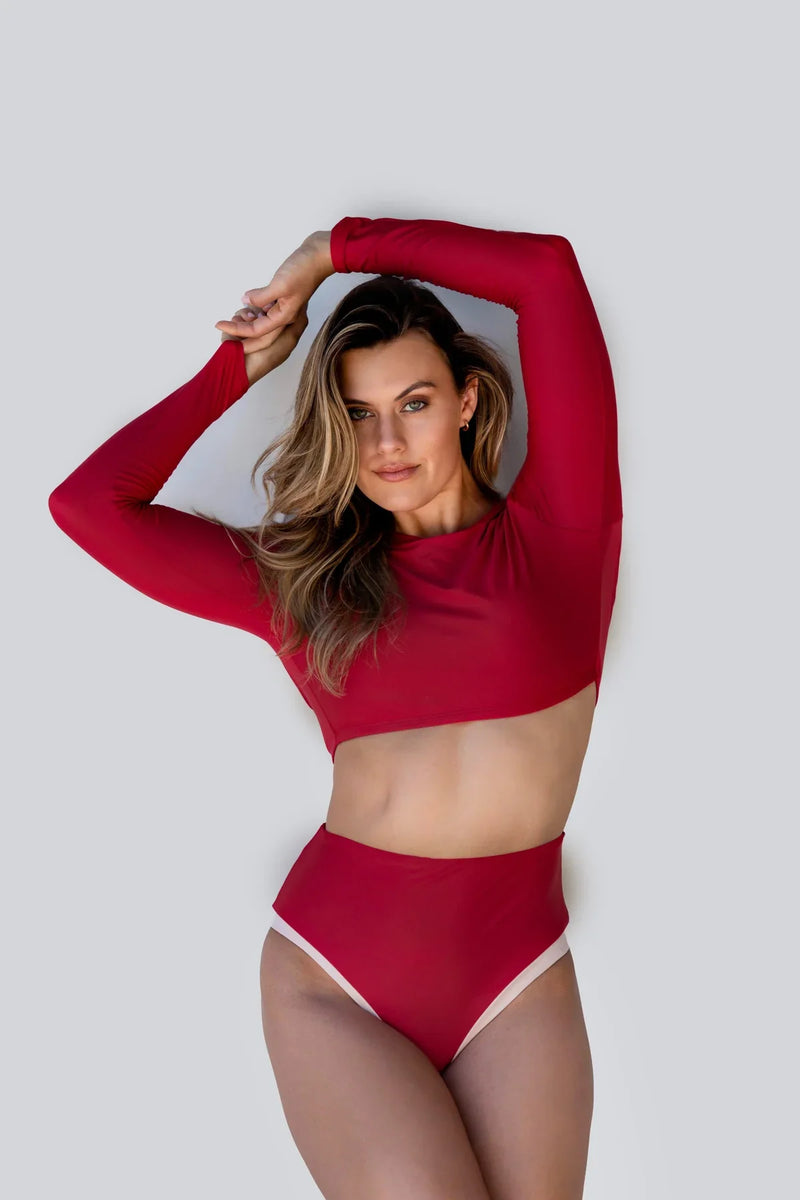 A model in a red rash guard bikini